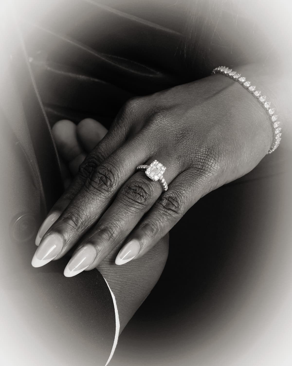 Close-up black and white photo of engagement ring and bracelet
